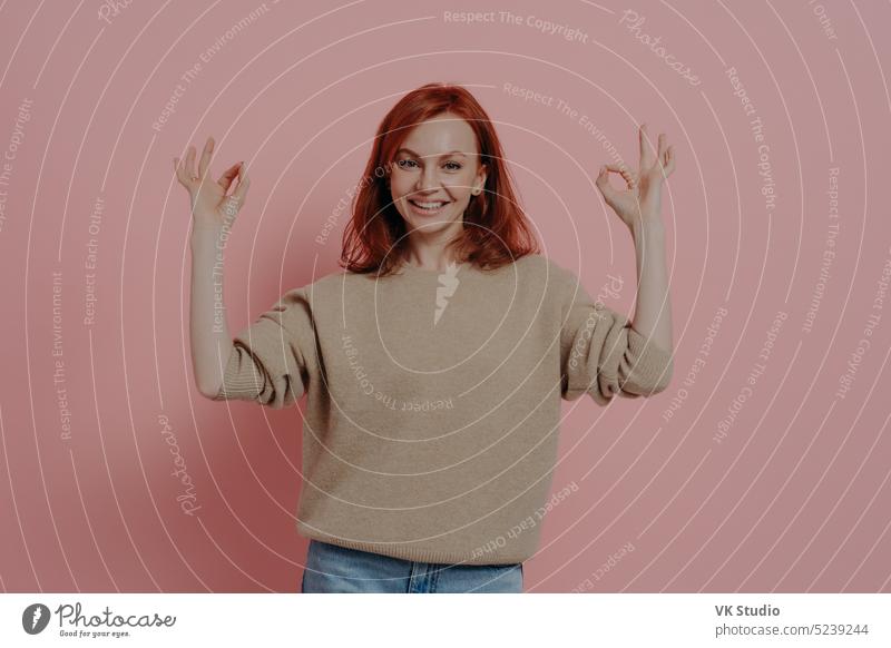 Half length shot of pretty ginger woman showing OK sign with both hands, isolated on pink ok young positive redhead okay approval gesture cheerful red-haired
