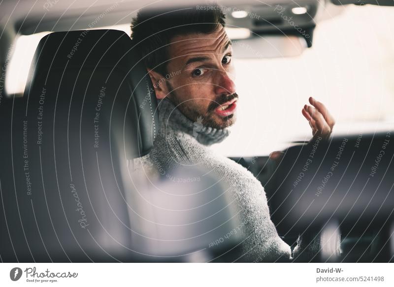 Angry man look backward cursing while driving car Motoring rabid Curse Man Car aggression Self Control Road traffic Scream Gesture Driving