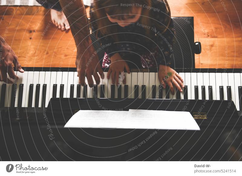Father and daughter play piano together Child Piano Music musical Playing Parenting Musician Make music fun Joy teach Explain Indicate Musical instrument