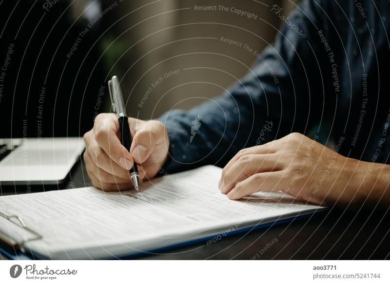 Businessman signs documents with a pen making the signature contract and partnership on desk. signing job writing agreement paperwork hand manager insurance