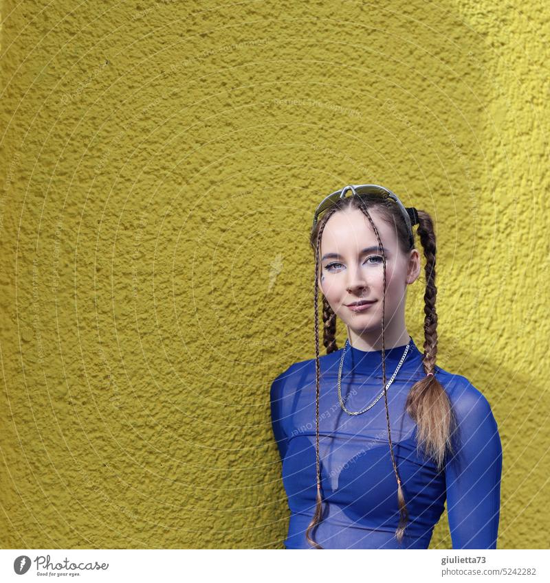 Generation Z teenage girl - styled with braids in cool blue techno outfit in front of yellow wall favourite person 18-20 years Fishnet shirt Caucasian