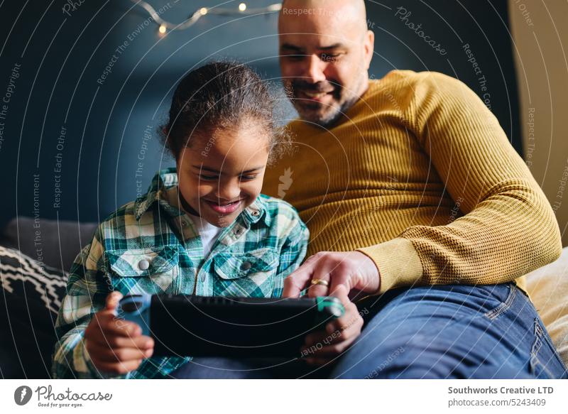 Boy with Down syndrome smiling and playing computer game with father boy son lifestyle smile multiracial down syndrome video man happy cheerful watch help