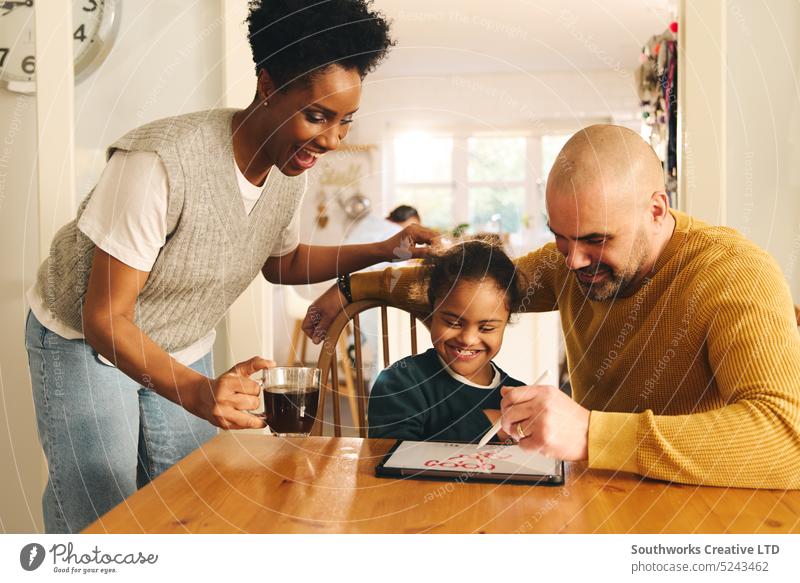 Parents and son with Down syndrome drawing on digital tablet family parent down syndrome lifestyle multiracial black woman boy child elementary adult mature