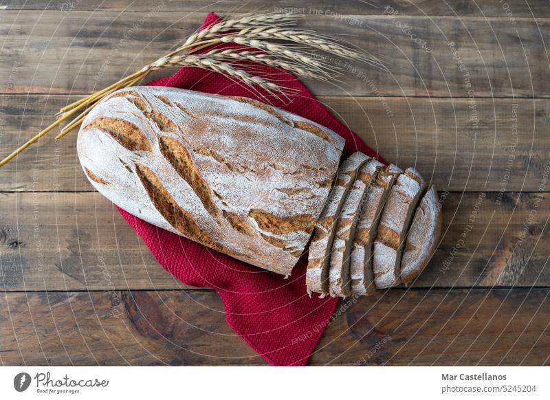 Piece of rustic bread on wooden background with ornaments of ears of wheat. Copy space. Bread food piece cereal boards top view copy space bread piece bakery