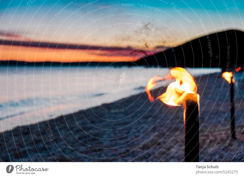 Sunset on beach with torch Beach Torch Flame Light evening mood Ocean ultra robbery Horizon coast bank