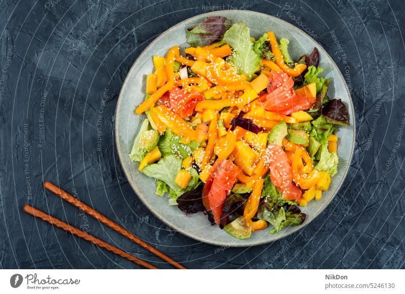 Asian salad with salmon. vegetable seafood fish fresh healthy diet avocado salted salmon salad appetizer dinner dish smoked salmon sticks plate flat lay recipe