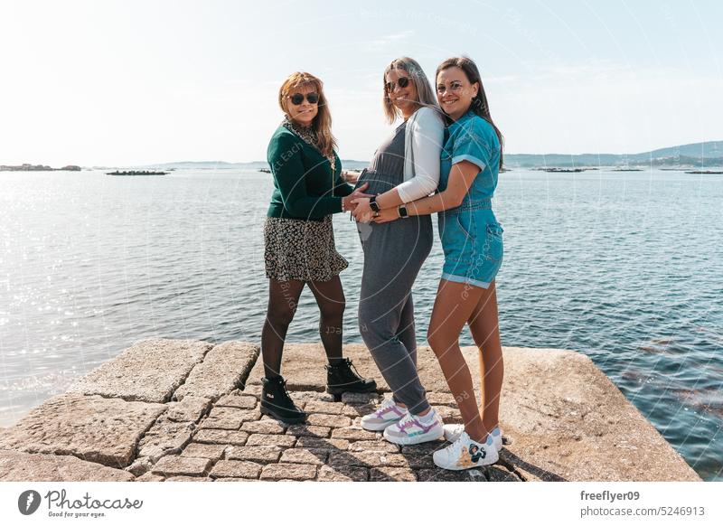 Pregnant woman with her mother and sister pregnant tourists ocean group females three love family boy girl joy children wait smile motherhood home dream preteen
