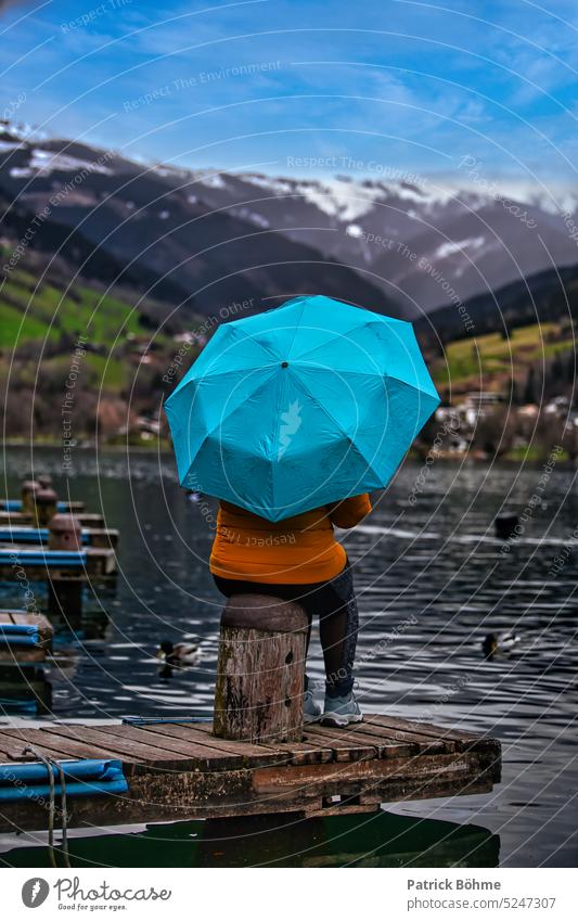 Woman with blue umbrella in front of a lake Umbrella Blue Mountain Lake Footbridge Water Landscape canon Photography Series of photos