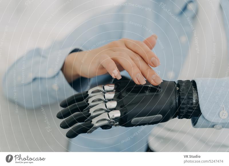 Female turns on high tech prosthetic hand, artificial limb. Advertising of bionic prosthesis disability female disabled arm close up finger gesture human
