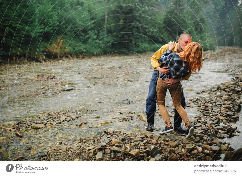 Playful happy handsome couple having while walking in woods. tourists in the mountains. Adventure in nature concept. couple in the mountains active relationship