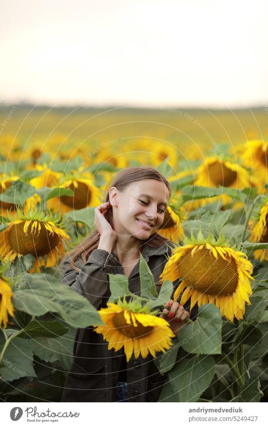 young beautiful woman on blooming sunflower field in summer, health and lifestyle beauty countryside freedom fresh joy portrait relaxing sunny summertime
