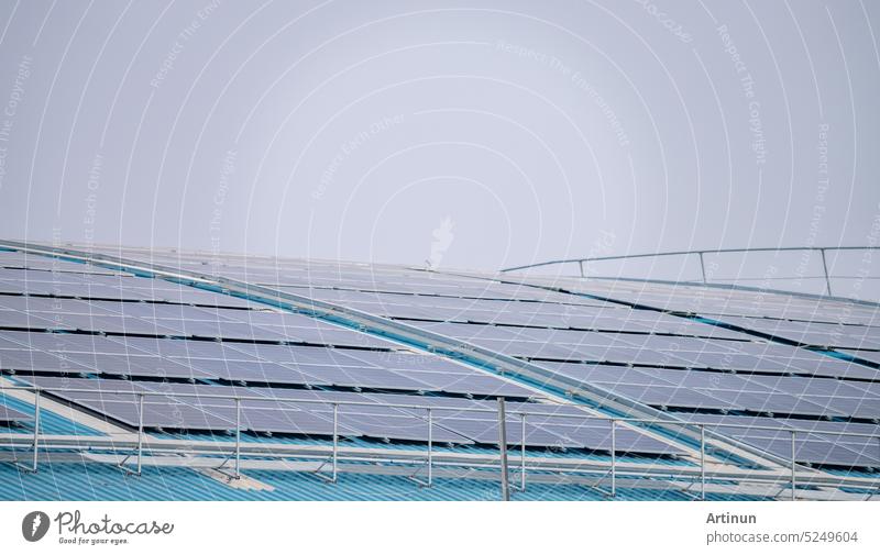 Solar energy for factory or warehouse building. Solar panels on the roof of industrial plant. Commercial solar. Industrial photovoltaic panels. Rooftop solar power. Green energy. Sustainable energy.