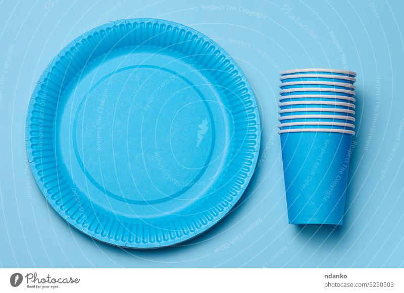 Round disposable blue paper plates and cups for a picnic, recyclable waste, top view. recycling environment sustainable ecology eco-friendly compostable