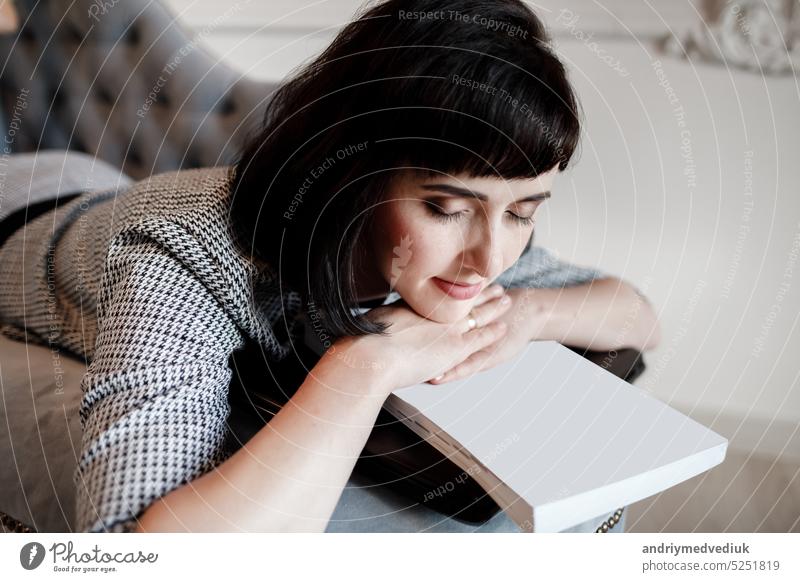 Tired young woman or Entrepreneur sleeping on sofa after long hours work on laptop, Overworked exhausted. businesswoman is resting her head on a empty papers and computer,feeling stressed out. mock up