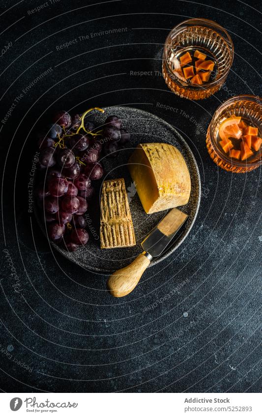 Black stone plate with cheeses and raw tasty grape appetizer assortment background cow cutlery cutting board dairy dark eat fermented food fresh glass goat