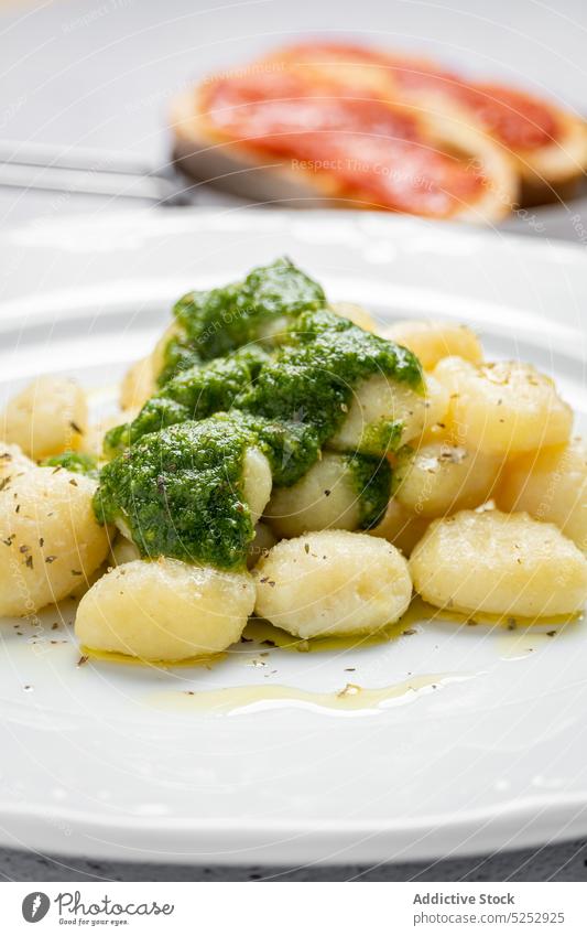 Delicious gnocchi with pesto sauce on plate toast serve portion culinary recipe food rustic table homemade cuisine appetizing kitchen yummy delicious towel