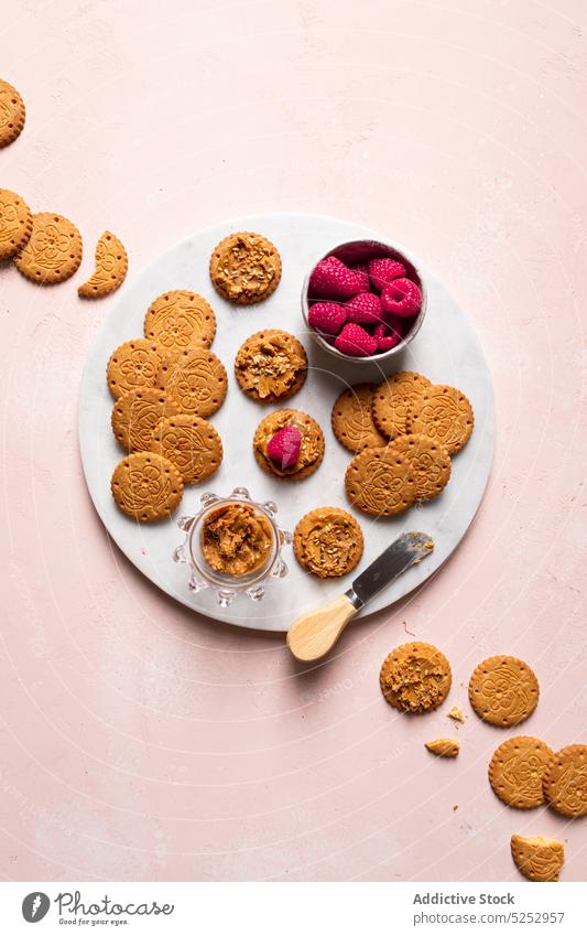 Delicious biscuits with peanut butter and raspberries served on table cookie raspberry sweet homemade delicious dessert baked pastry teapot appetizing seed food