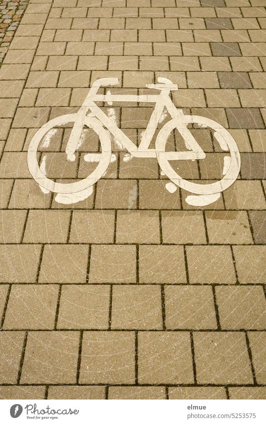 Remains of an old and a pictogram of a bicycle on stone slabs lying above it Bicycle cycle path Cycle path Pictogram Stone slab Ride a bike! Cycling Wheel