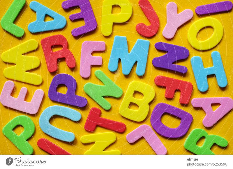different colored letters on yellow background / letter salad Write variegated Colour Foam rubber Blog writing alphabet Characters Alphabet font Typography