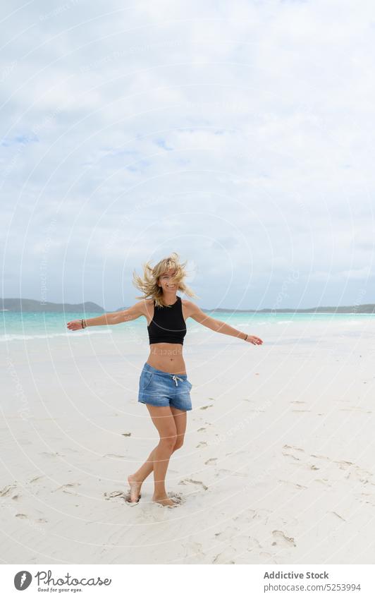 Happy young woman spinning around on beach spin around dance ocean sand nature vacation summer happy positive australia coast sea shore casual female joy
