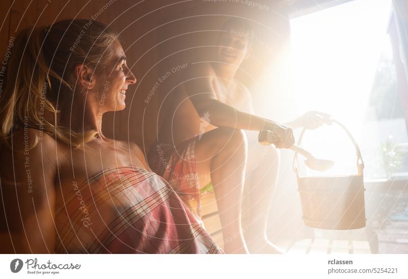 Two people - a couple - enjoying a hot sauna, having a casual conversation harmony fitness friends steam spa finnish hot stone hotel room bucket sweat