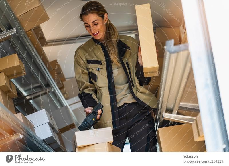 female delivery agent scanning barcode and holding parcel inside her van in the city. Courier Delivery concept image smiling happy service delivery man order