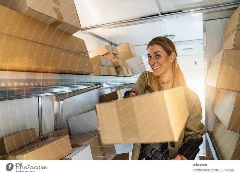 delivery agent presents a parcel in her van to deliver it to a customer. Courier Delivery concept image grab barcode scanner holding deliveryman smiling happy