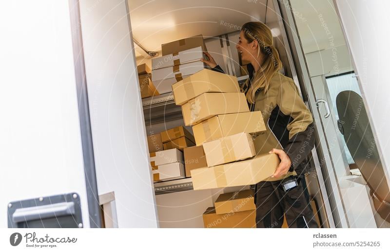 female delivery agent holding parcels in her van to deliver it to a customer grab barcode scanner deliveryman smiling happy service order mail storage equipment