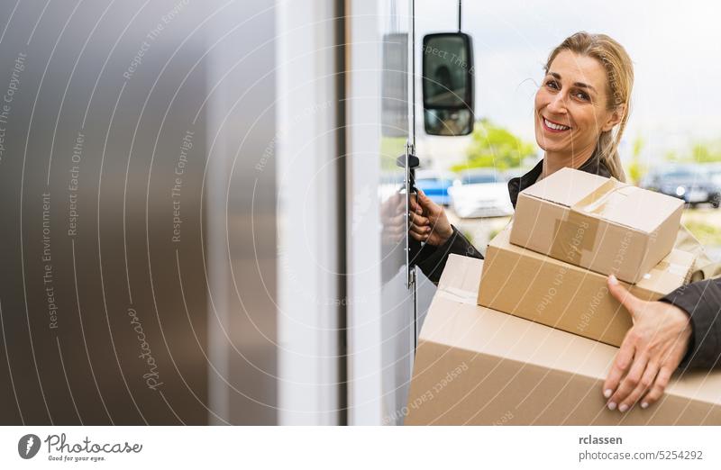 smiling female delivery agent holding parcels in front of a van to deliver it to a customer, with copy space for individual text grab barcode scanner