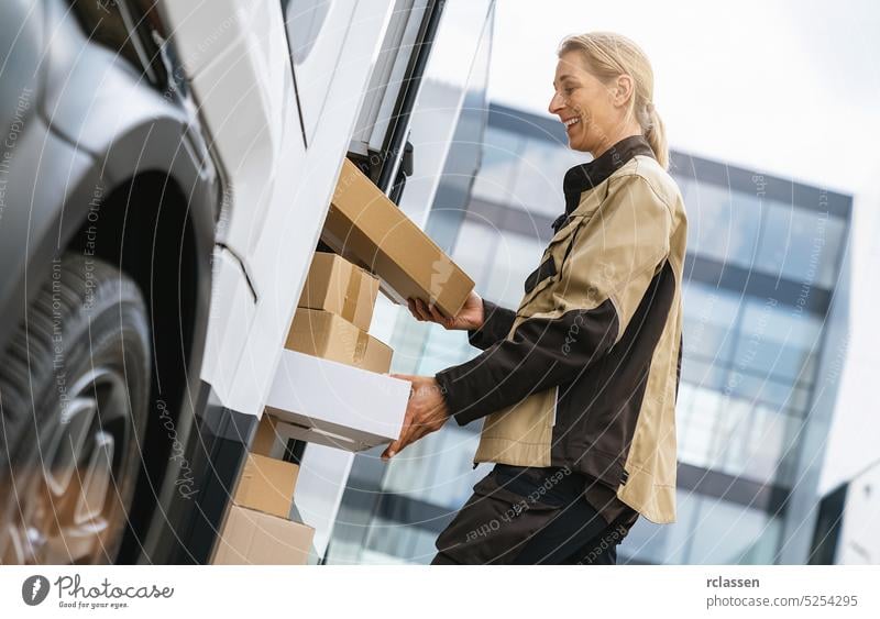 female delivery agent taking out parcels from a van to deliver it to a customer. Courier Delivery concept image grab barcode scanner holding deliveryman smiling