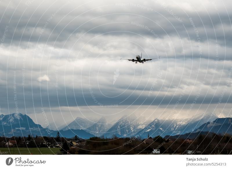Airplane over mountain range landing approach Sky Clouds Airport Airplane landing Exterior shot Mountain range Passenger plane vacation Freedom Flying Tourism