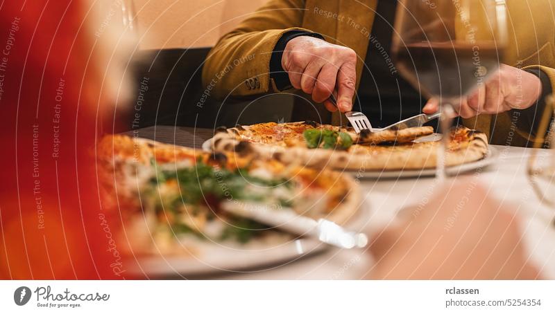 Couple drinking wine eating pizza  with a fork and knife in a italian restaurant margherita couple rendezvous slice cheese basil london new york taste friends