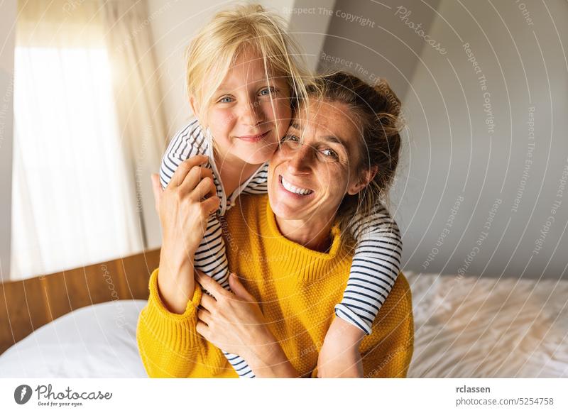 Happy daughter giving mother piggybacking smiling at camera. Good time at home concept image mom family happy mother kid young child healthy lifestyle woman