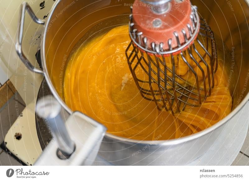 Mixing baking ingredients with egg yolks and sugar in large food mixer for cake or pancakes. Bakery shop concept. speed kitchen milk cooking breakfast bakery