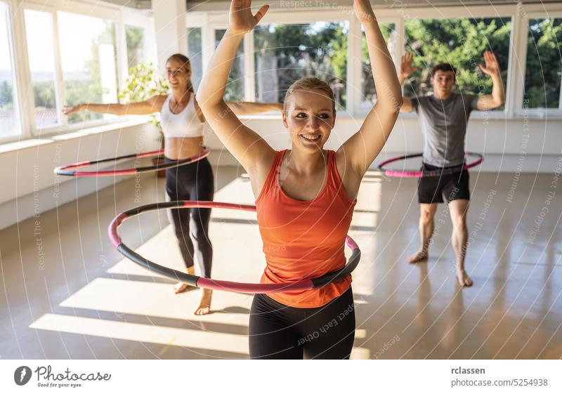 Young women an men doing hula hoop during an exercise class in a gym. Healthy sports lifestyle, Fitness, Healthy concept. club happy team building team concept