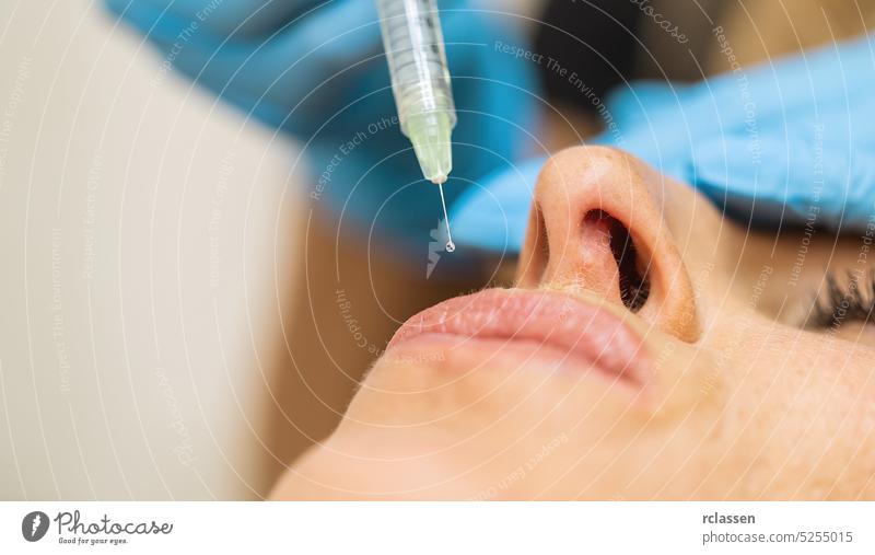 Close up of cosmetic Anti-aging face injection in female lips. cosmetologist using syringe with special liquid. Concept of cosmetology, beauty. gloves aesthetic