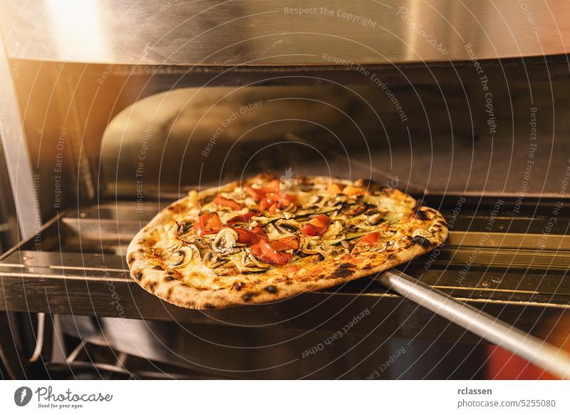 Pizza inside an oven in the italian pizzeria wood fire brick oven chef cook gourmet professional work traditional stove italy hot man people crust service food