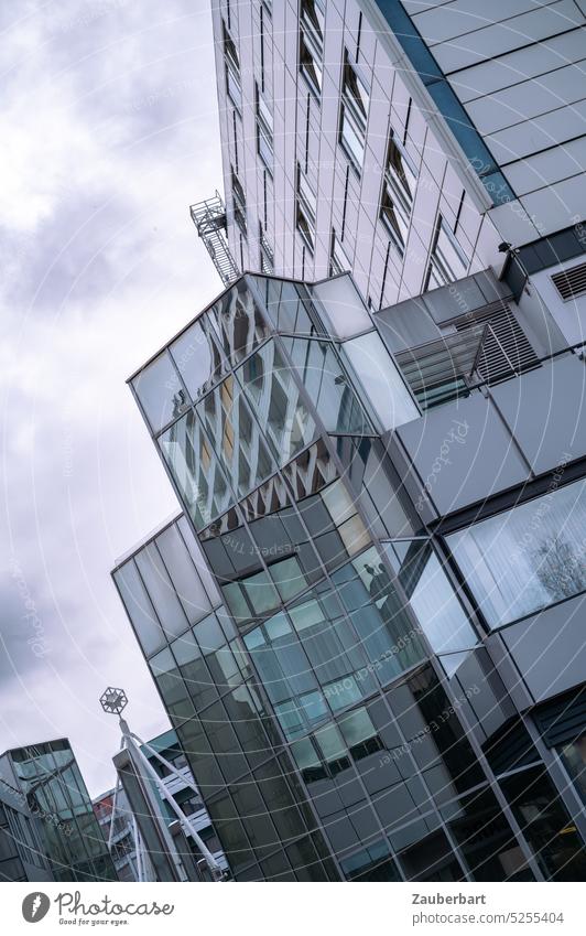 Modern glass facade in the city tilted against dramatic sky Facade Glass Glas facade tip Dramatic Sky Gray Town urban Cold chill uncomfortable Comfortless