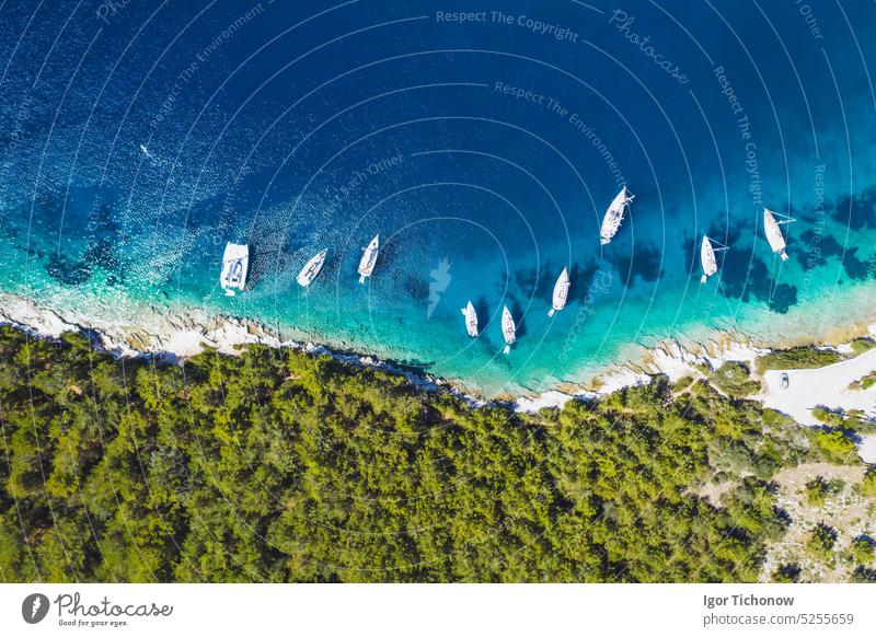 Top down aerial view of sailing boats docked in blue bay of Fiskardo, Kefalonia island, Ionian, Greece kefalonia greece fiskardo ionian drone village landscape