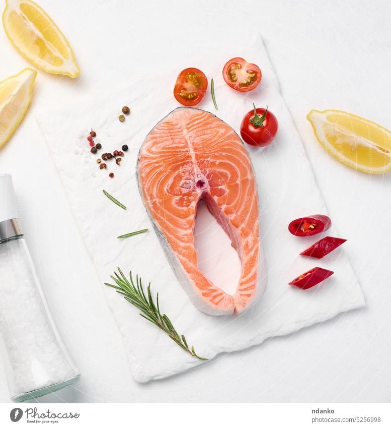 Raw piece of salmon, lemon slices and spices on a white board, top view raw fish food fresh background seafood fillet healthy red steak gourmet ingredient