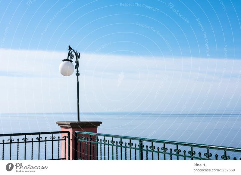 Lantern on a roof terrace with sea view Lamp outlook Horizon Blue sky Beautiful weather Roof terrace rail Iron railing