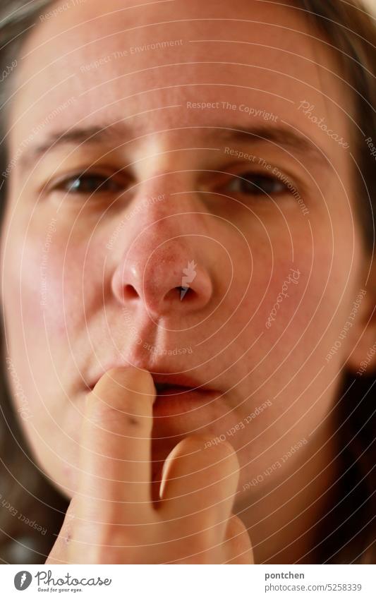 a woman looks skeptical, ponders and bites her fingernail Skeptical brood think fingernail biting Woman Face Think Emotions Neutral Background facial expression