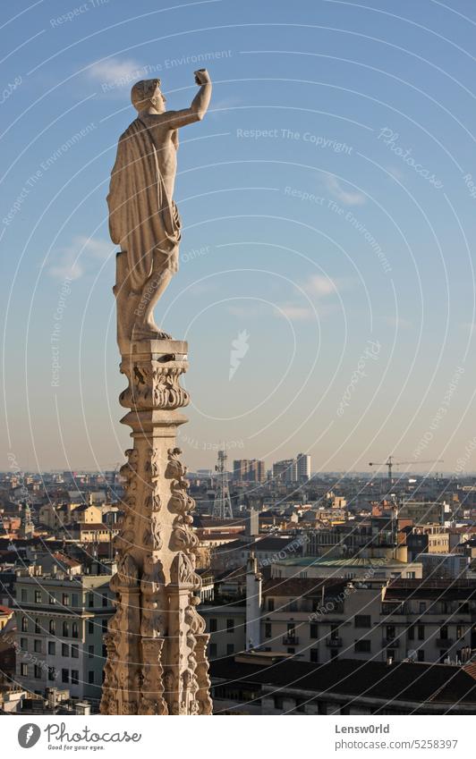 Statue with raised fist on the cathedral in Milan, Italy church city cityscape defiance europe european guard guardian italian italy landmark milan monument old