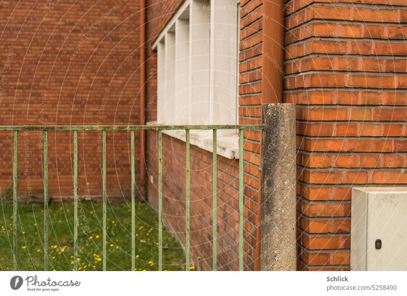 Brick architecture and fence from iron bars in green Architecture Fence Iron Meadow Window power box Concrete post Red Brown White Green downspout