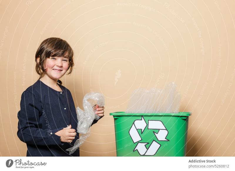 Cheerful girl smiling and sorting garbage recycle smile box happy ecology symbol kid casual cheerful positive glad candid glass plastic child container optimist