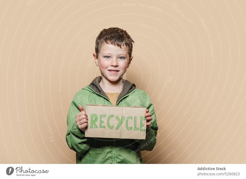 Boy showing Recycle placard at camera boy recycle protest activist environment ecology response carton kid outerwear coat problem save child reduce protect