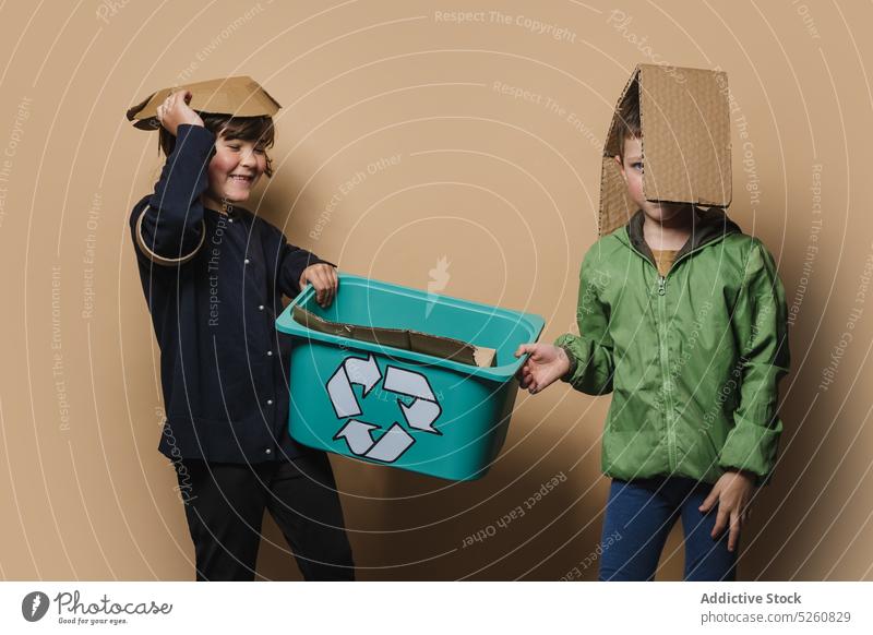 Siblings playing with pieces of carton sibling cardboard recycle box children happy together carry symbol boy girl sister brother kid reduce response playful