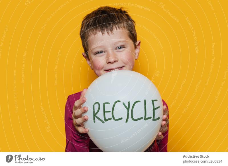 Glad boy with recycle balloon happy show smile environment ecology colorful bright casual kid inscription positive cheerful child glad vivid optimist candid