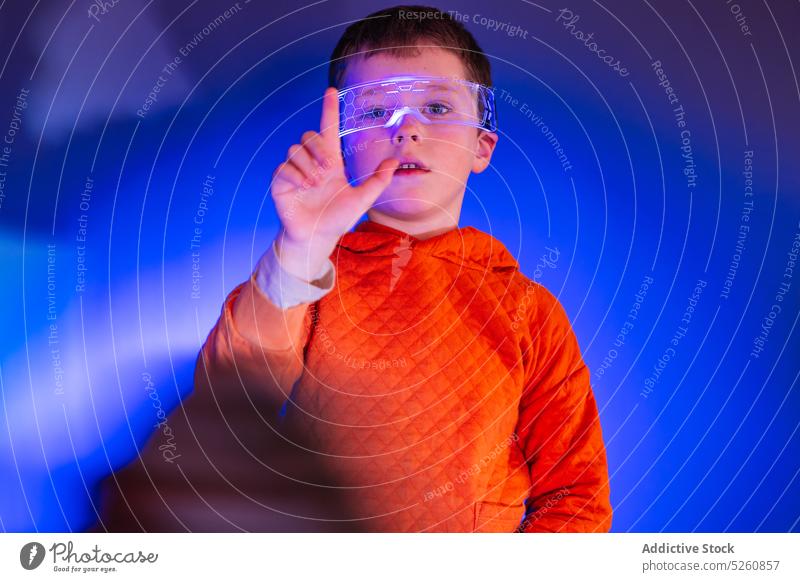 Little boy in smart goggles exploring virtual reality kid vr experience innovation device imagination simulator child explore digital technology simulate modern