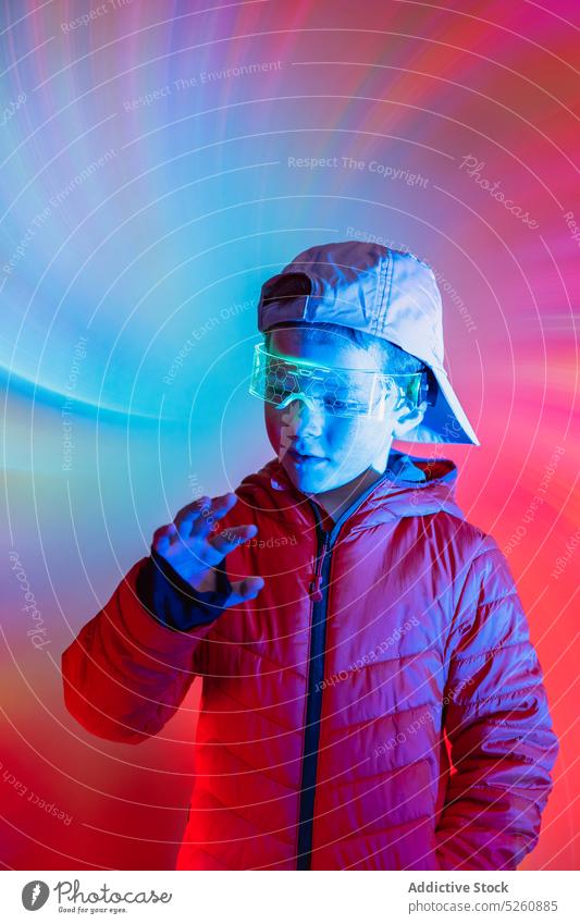 Futuristic boy interacting with digital interface futuristic cyberspace control press neon illuminate bright style glasses goggles modern virtual reality vr